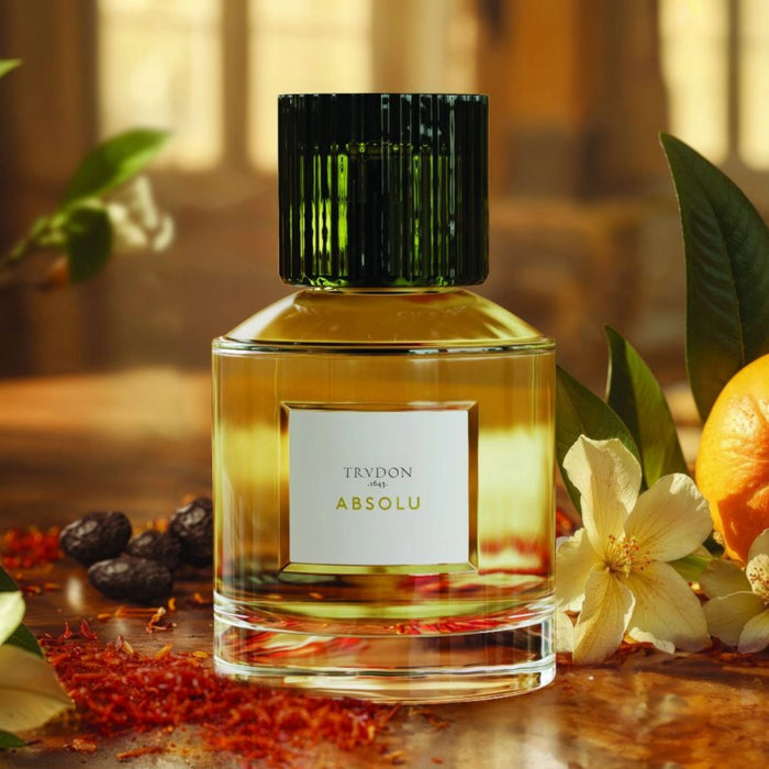 Trudon - Absolu Parfümflakon mit grün gerilltem Verschluss und goldenem Inhalt vor warmem Hintergrund
