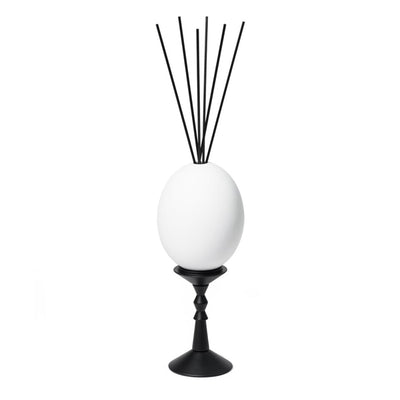 Trudon - L’Œuf Diffusor - Ernesto zeigt weißes Ei mit schwarzen Duftstäbchen auf elegantem schwarzem Ständer vor weißem Hintergrund